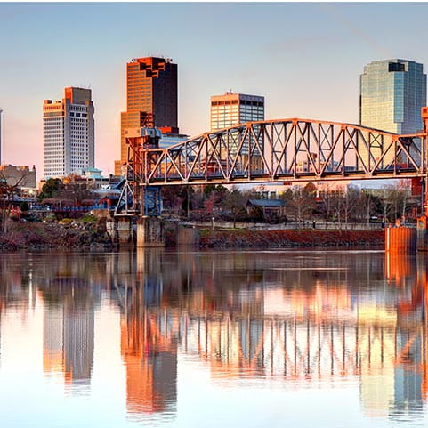 A city skyline with a bridge over water.