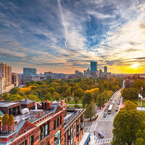 El horizonte de una ciudad al atardecer, con edificios altos y cielos coloridos.