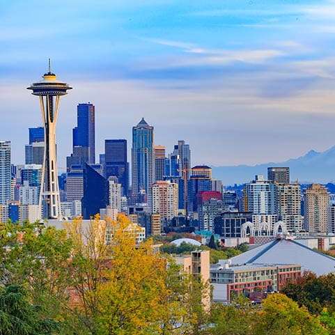 Seattle skyline with mountains in the background, overlooking a serene lake.