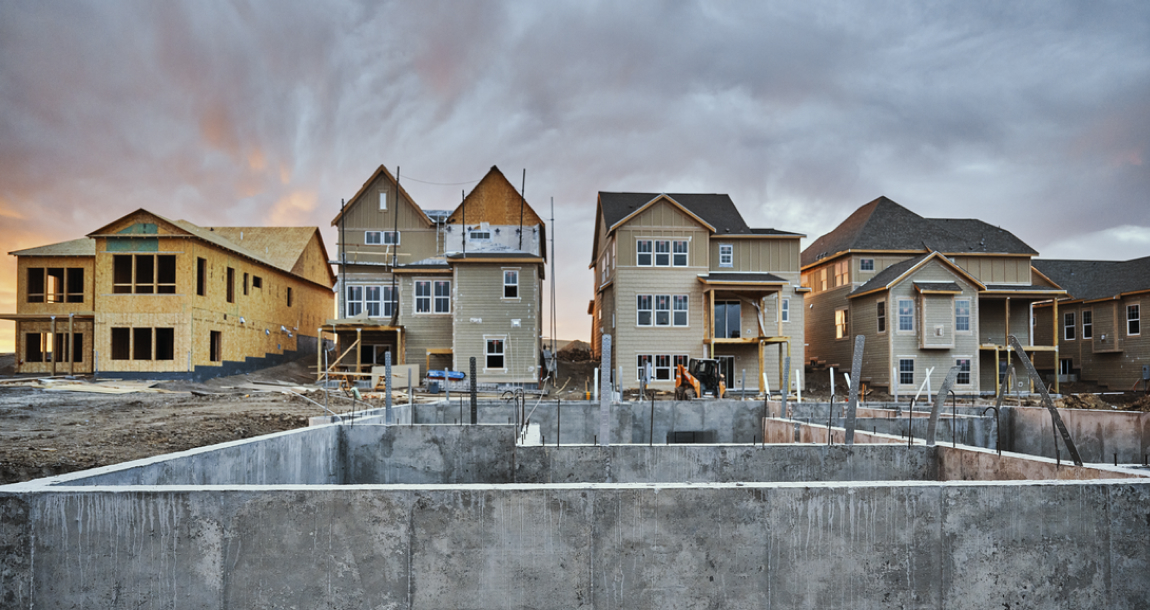 A picturesque sunset casts a warm glow on a cluster of houses under construction